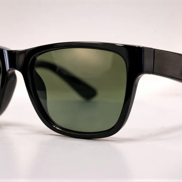 Close-up of black rectangular sunglasses with dark green tinted lenses and premium glossy finish